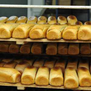 loaves of bread on a rack in a factory